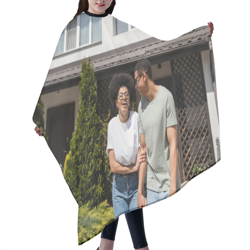 Personality  Excited African American Woman Standing Near Boyfriend And New House On Background Outdoors Hair Cutting Cape