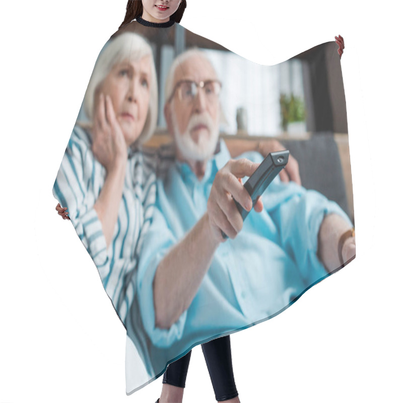 Personality  Selective Focus Of Focused Senior Couple Watching Tv On Couch In Living Room Hair Cutting Cape