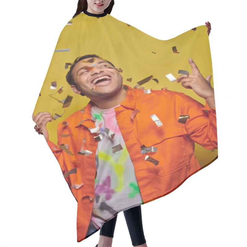 Personality  Excited Indian Man In Orange Jacket Gesturing Near Confetti On Yellow Backdrop, Party Concept Hair Cutting Cape