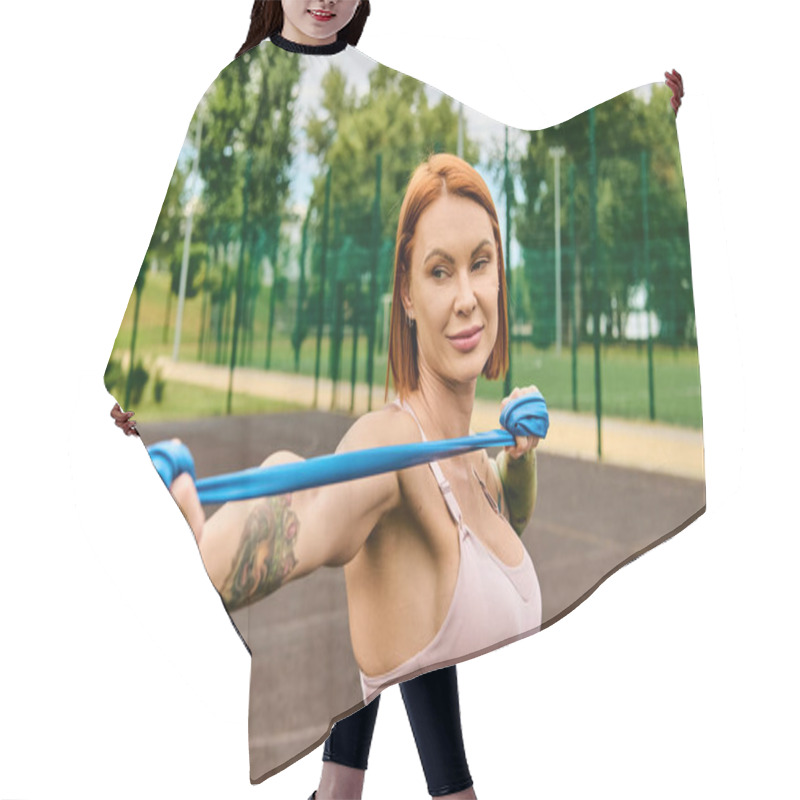 Personality  A Determined Woman In Sportswear Holds A Blue Resistance Rope, Showcasing Motivation. Hair Cutting Cape