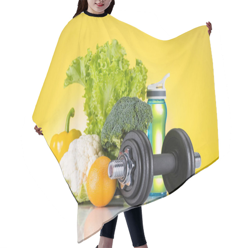 Personality  Close-up View Of Dumbbell, Bottle Of Water And Fresh Fruits And Vegetables On Yellow  Hair Cutting Cape