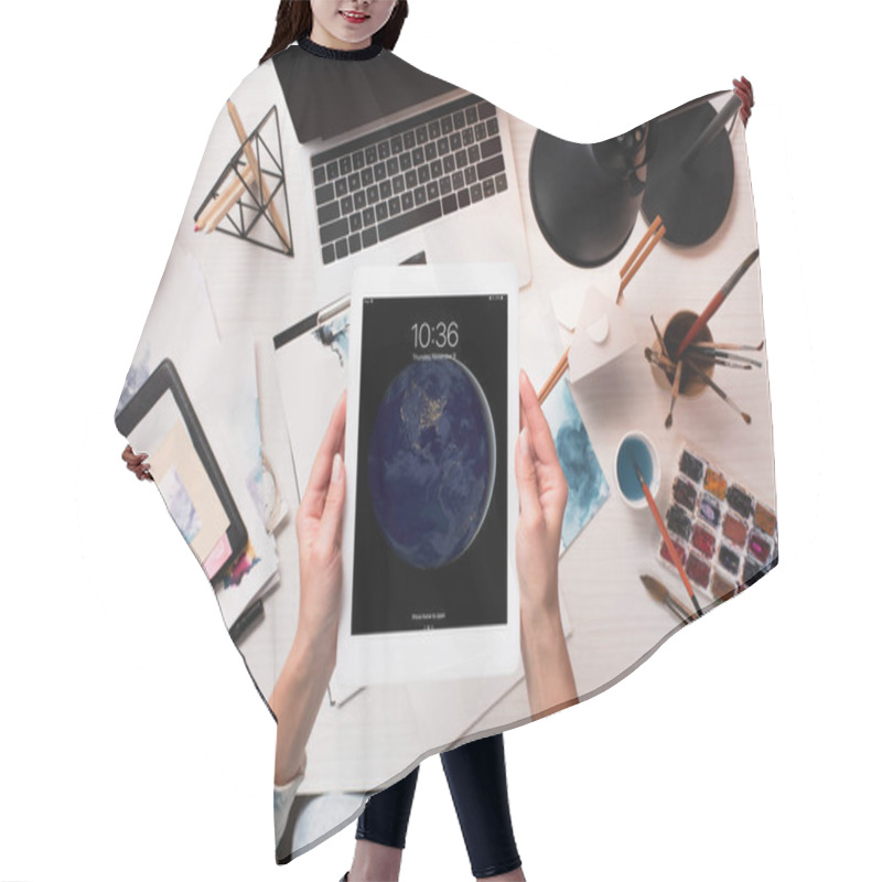 Personality  Cropped View Of Designer Holding Tablet With Apple Home Screen At Office Desk With Art Supplies, Flat Lay Hair Cutting Cape