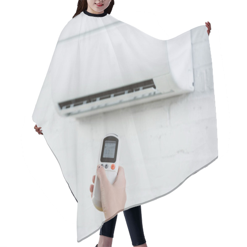 Personality  Cropped Shot Of Woman Pointing At Air Conditioner Hanging On White Brick Wall With Remote Control Hair Cutting Cape