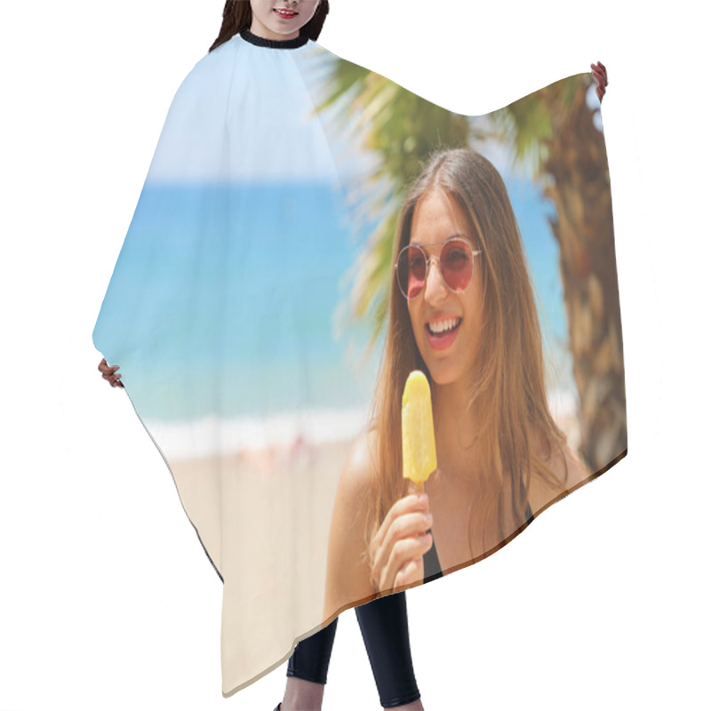 Personality  Smiling Beautiful Girl With Sunglasses Eating Popsicle On The Beach With Palm Trees On The Backgroud. Summer Holidays Concept And Copy Space. Hair Cutting Cape