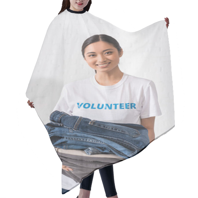 Personality  Asian Volunteer Holding Clothes And Looking At Camera In Charity Center  Hair Cutting Cape