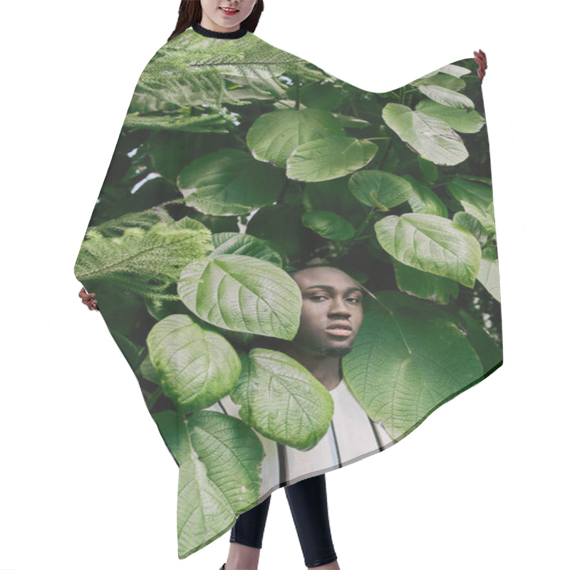 Personality  A Stylish African American Man Stands Confidently In Front Of A Lush Green Tree. Hair Cutting Cape