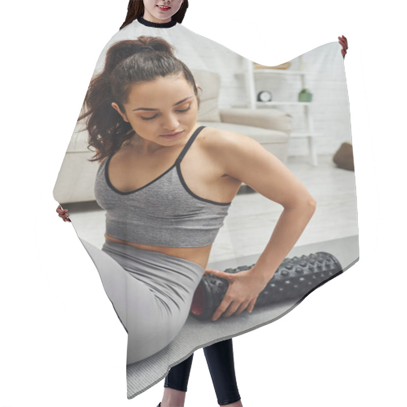 Personality  Young Brunette Woman In Activewear Holding Modern Roller Massager For Lymphatic Drainage And Sitting On Fitness Mat At Home, Sense Of Tranquility And Promote Relaxation Concept, Tension Relief Hair Cutting Cape