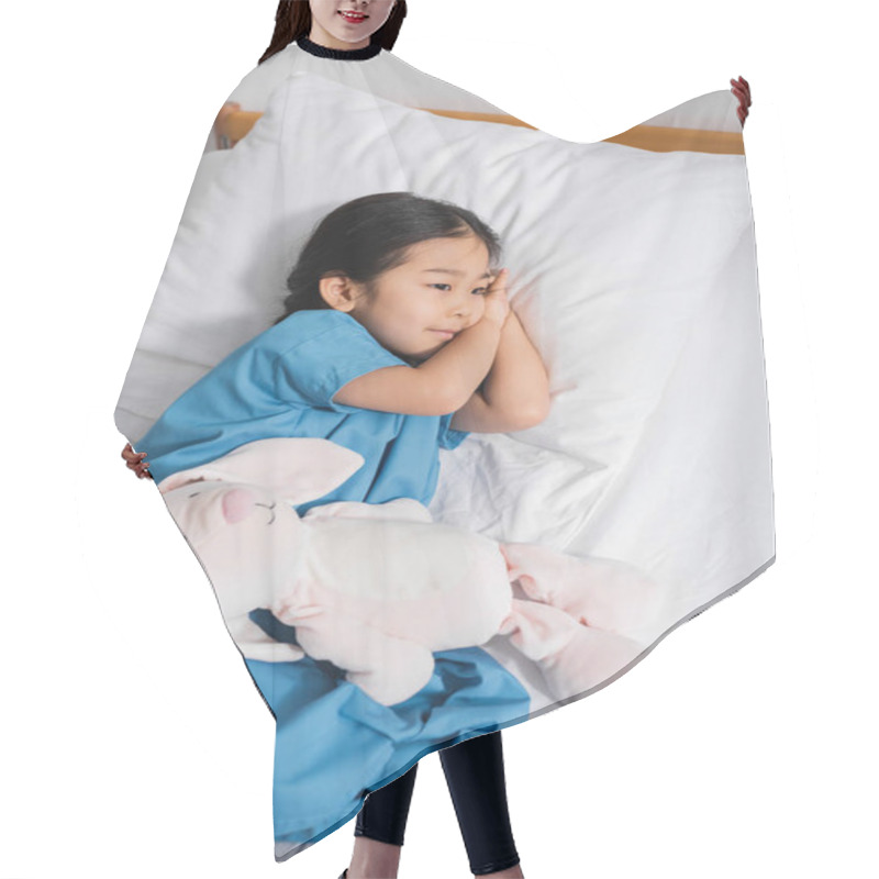 Personality  High Angle View Of Dreamy Asian Child Lying On Hospital Bed Near Toy Bunny And Looking Away Hair Cutting Cape