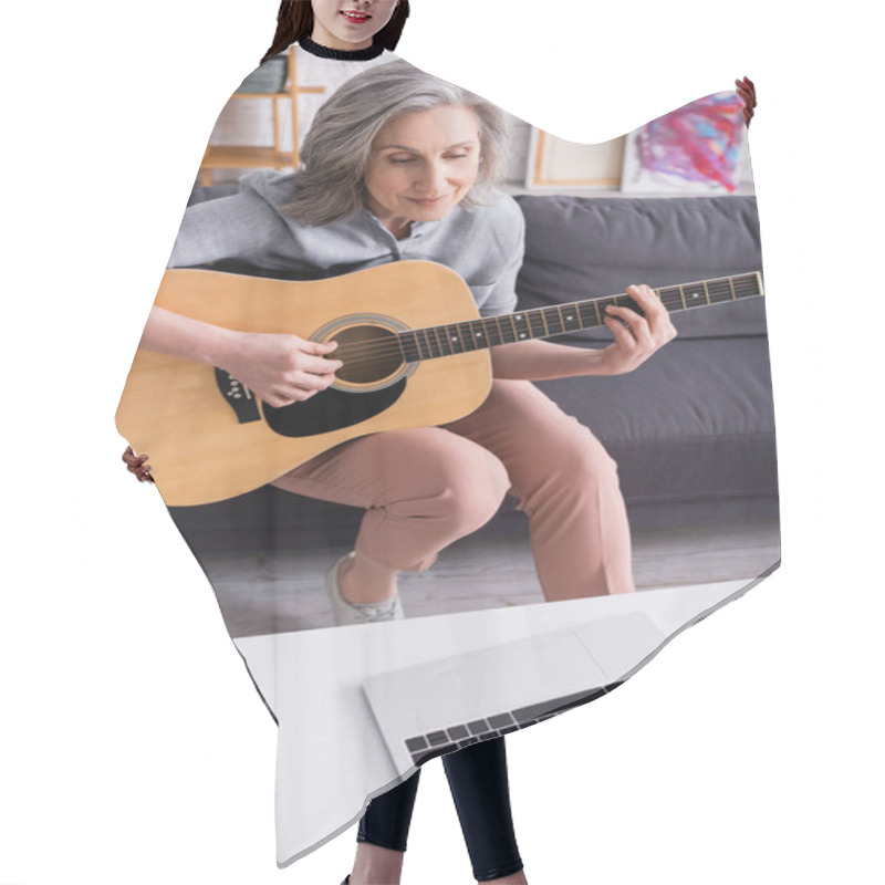 Personality  Middle Aged Woman With Grey Hair Learning To Play Acoustic Guitar Near Laptop With Blank Screen On Coffee Table Hair Cutting Cape