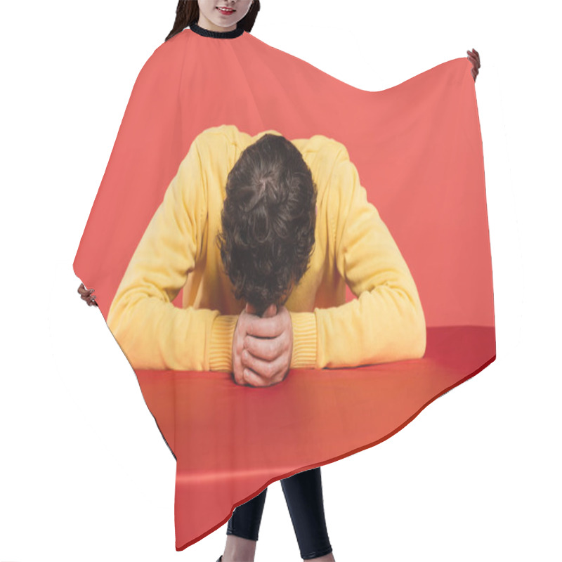 Personality  Curly Man In Yellow Long Sleeve Jumper Sitting With Bowed Head At Table Isolated On Coral Background  Hair Cutting Cape