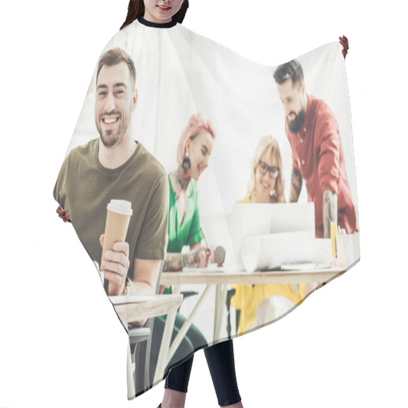 Personality  Selective Focus Of Smiling Man With Coffee To Go And Creative Colleagues Working Behind In Office Hair Cutting Cape