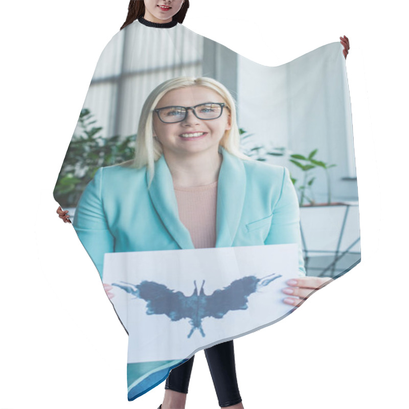 Personality  Smiling Psychologist In Eyeglasses Holding Rorschach Test In Consulting Room  Hair Cutting Cape