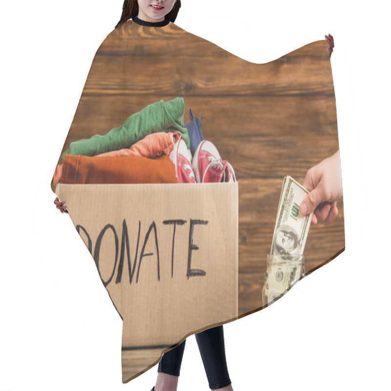 Personality  Cropped View Of Man Putting Money In Jar Near Cardboard Box With Donate Lettering And Clothes On Wooden Background, Charity Concept Hair Cutting Cape