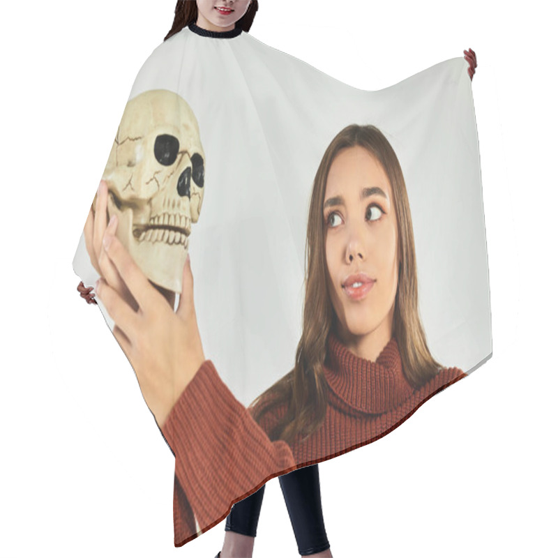 Personality  A Young, Beautiful Woman In A Sweater Holds A Skull, Embodying Halloween Vibes With Curiosity. Hair Cutting Cape