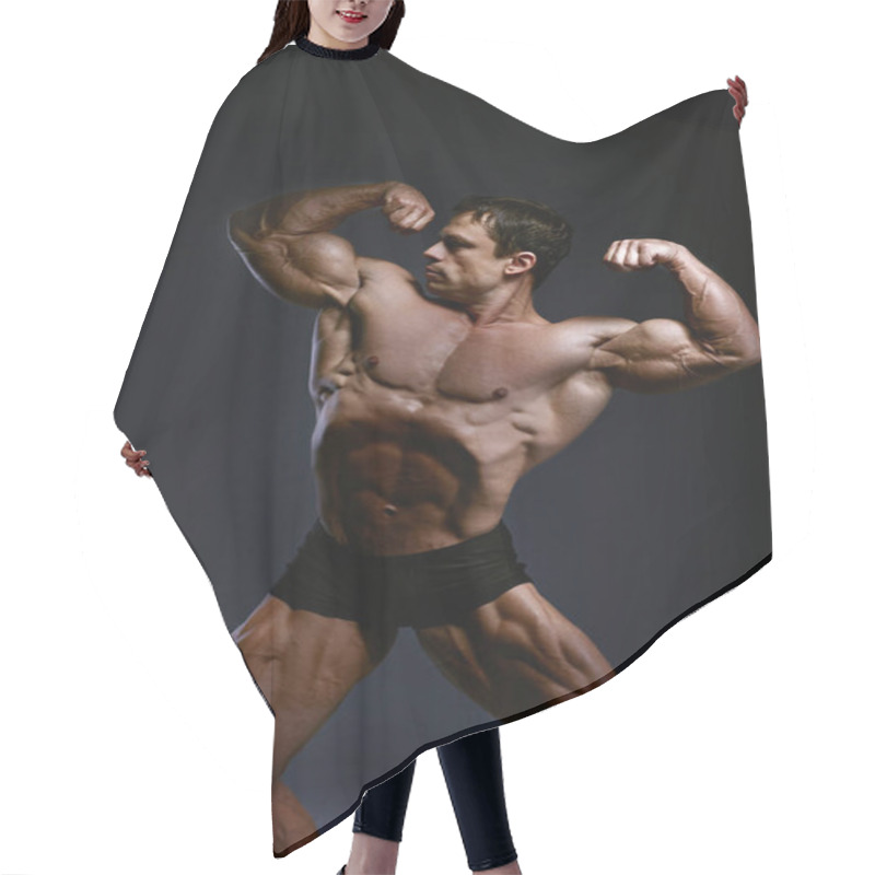 Personality  Bodybuilder Athlete Shows Muscles In The Studio On A Dark Background. Bodybuilder Posing. Hair Cutting Cape