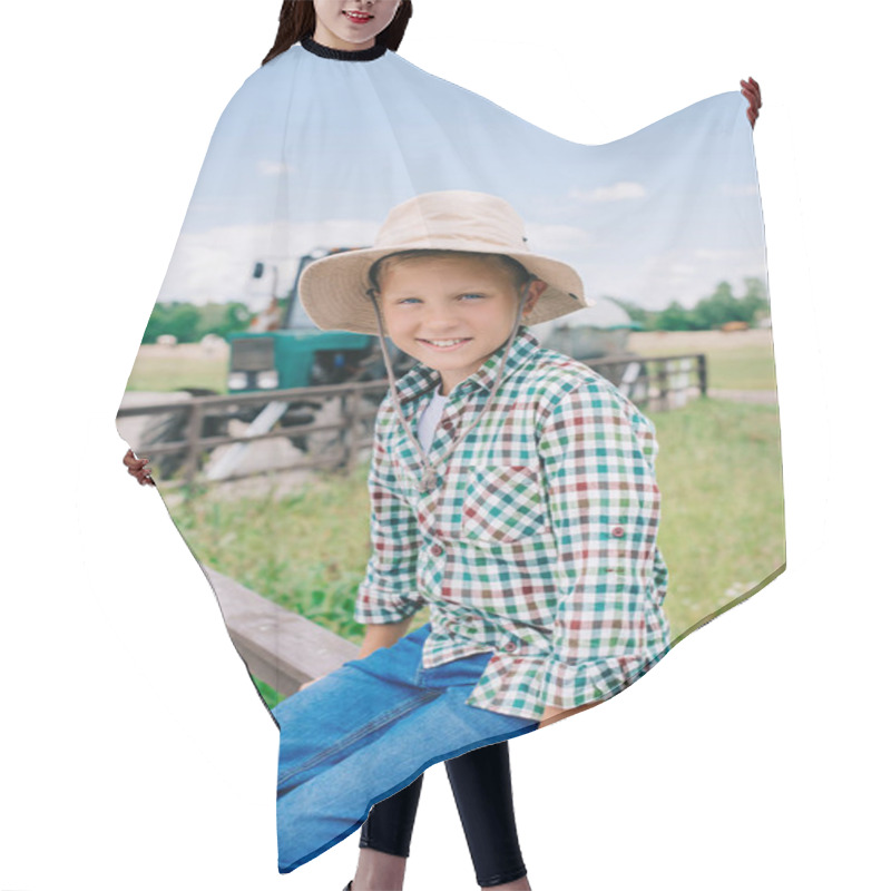 Personality  Cheerful Boy In Panama Hat Sitting On Fence And Smiling At Camera On Farm  Hair Cutting Cape