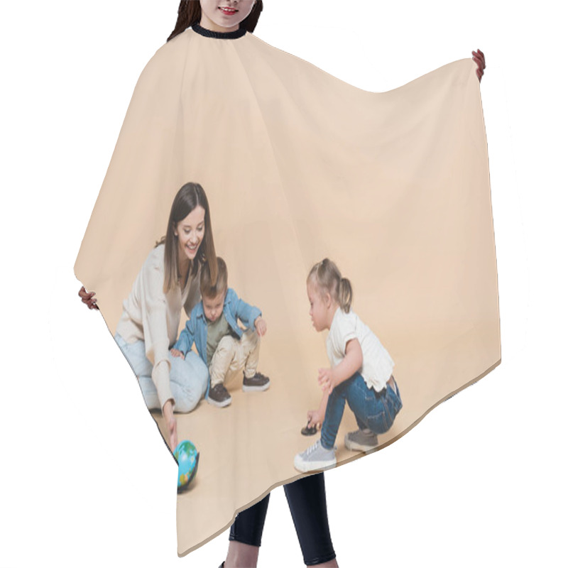 Personality  Happy Woman Playing With Globe Near Toddler Boy And Girl With Down Syndrome On Beige Hair Cutting Cape