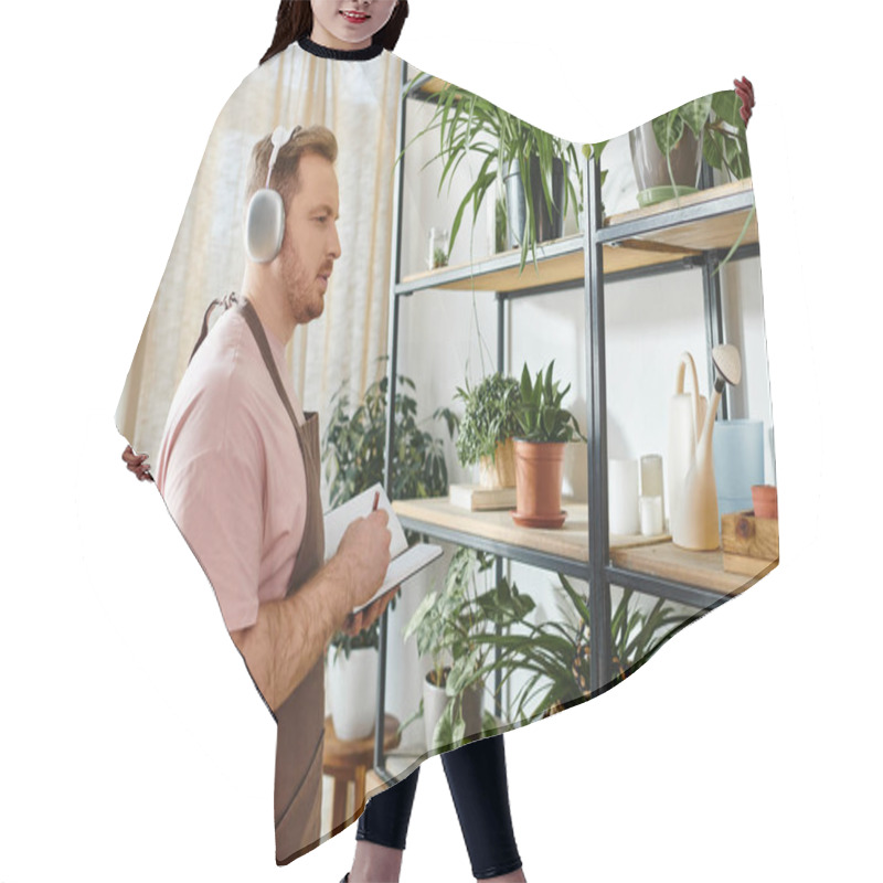 Personality  A Man In Headphones Surrounded By Lush Green Plants In A Small Shop. Hair Cutting Cape