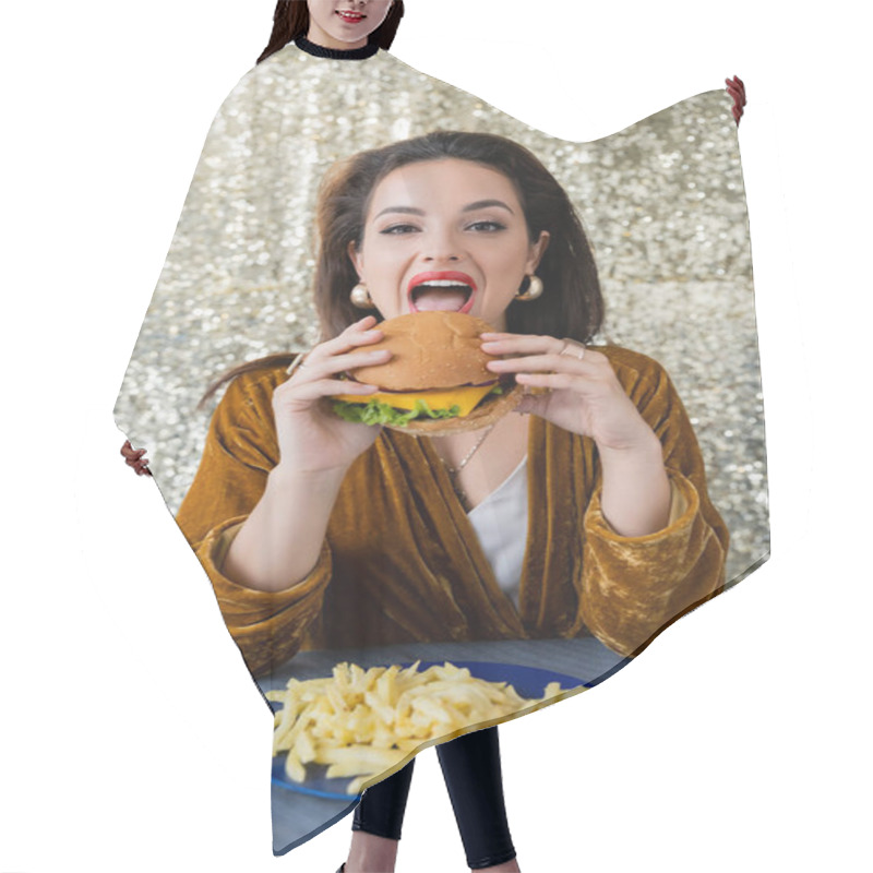 Personality  Brunette Elegant Woman Looking At Camera While Eating Burger Near French Fries On Shiny Silver Background Hair Cutting Cape