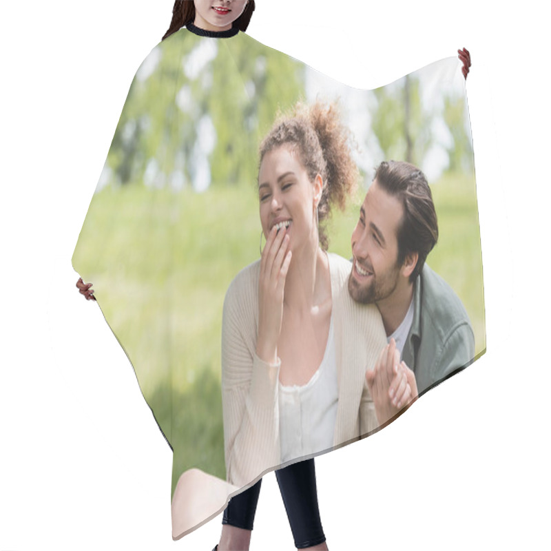 Personality  Happy Man And Cheerful Woman Laughing While Covering Mouth In Park Hair Cutting Cape