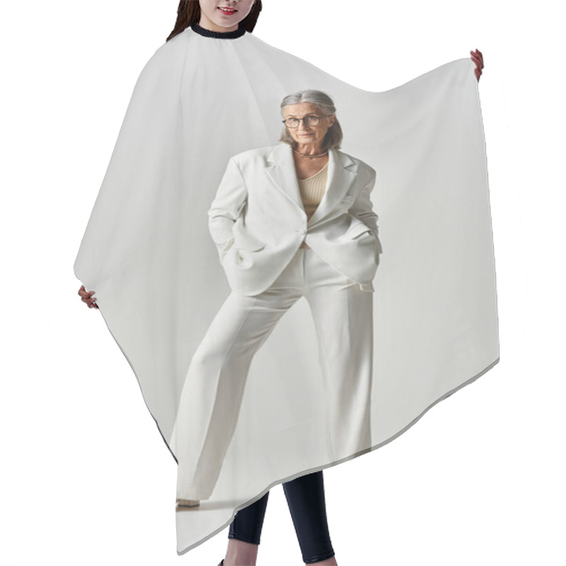 Personality  A Mature Woman With Grey Hair Showcases Her Elegance In A Chic White Suit On A Muted Grey Background. Hair Cutting Cape