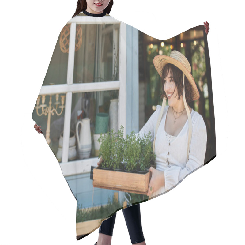 Personality  A Woman In A White Dress And Straw Hat Smiles While Carrying A Tray Of Potted Plants In A Sunny Summer Garden. Hair Cutting Cape