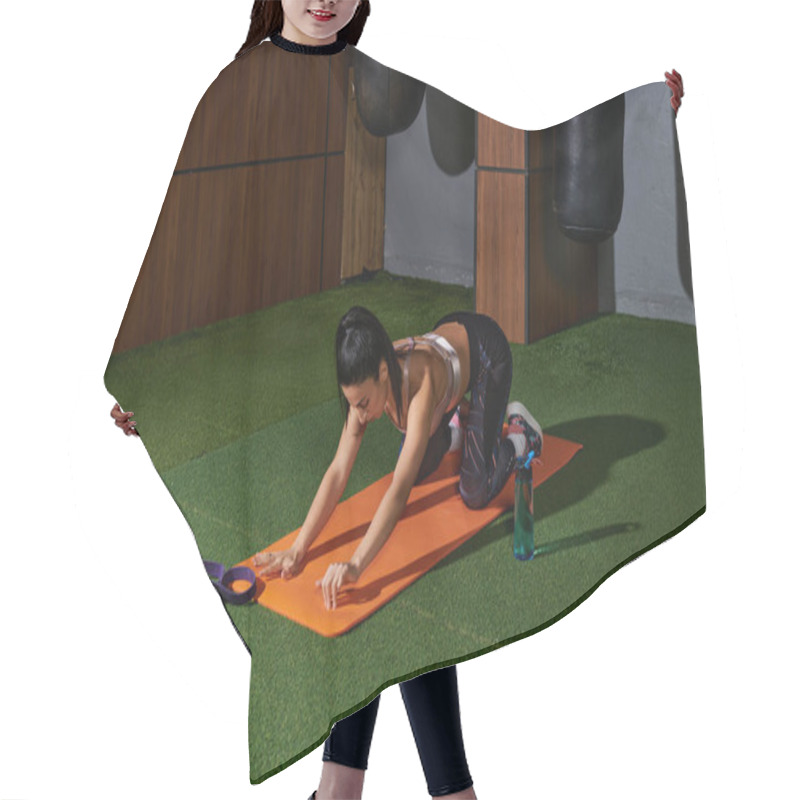 Personality  Dedicated Woman Performs Stretching Exercises On Mat In A Contemporary Gym Environment. Hair Cutting Cape