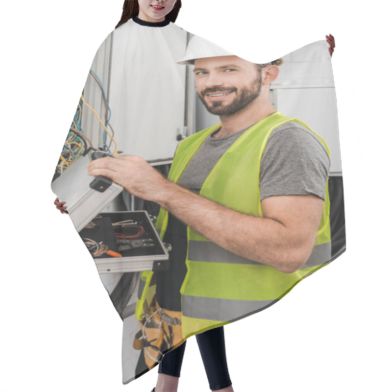 Personality  Smiling Handsome Electrician Holding Toolbox Near Electrical Box In Corridor And Looking At Camera Hair Cutting Cape