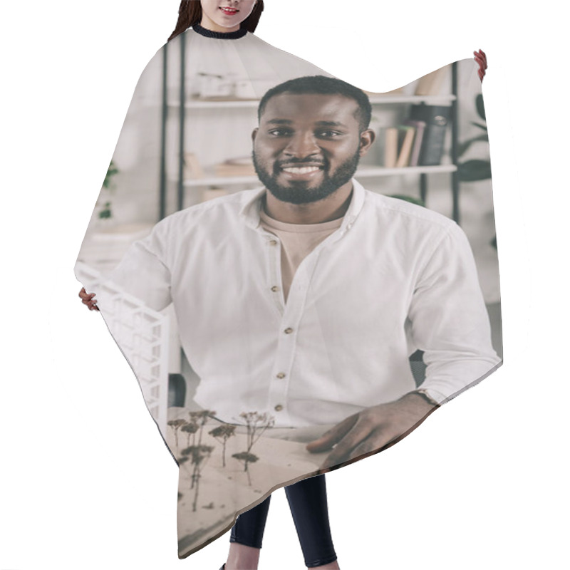 Personality  Smiling African American Architect Sitting Near Architecture Model On Table In Office And Looking At Camera Hair Cutting Cape