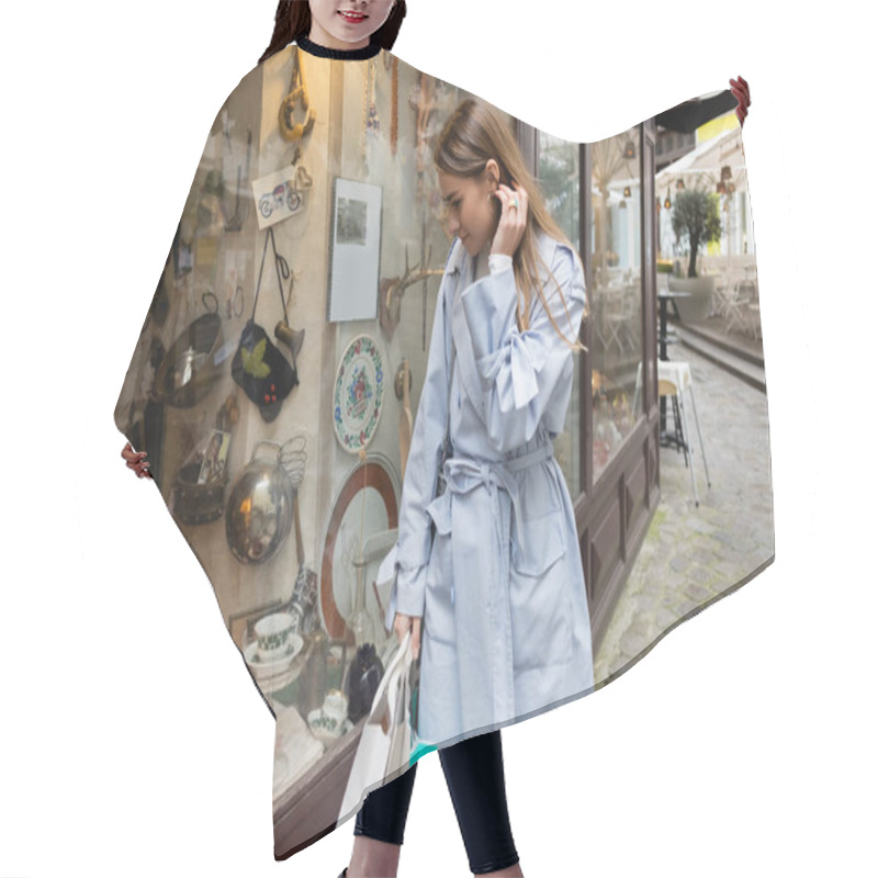 Personality  Young Woman In Trench Coat Standing With Shopping Bags And Looking At Showcase Of Antique Shop In Vienna  Hair Cutting Cape