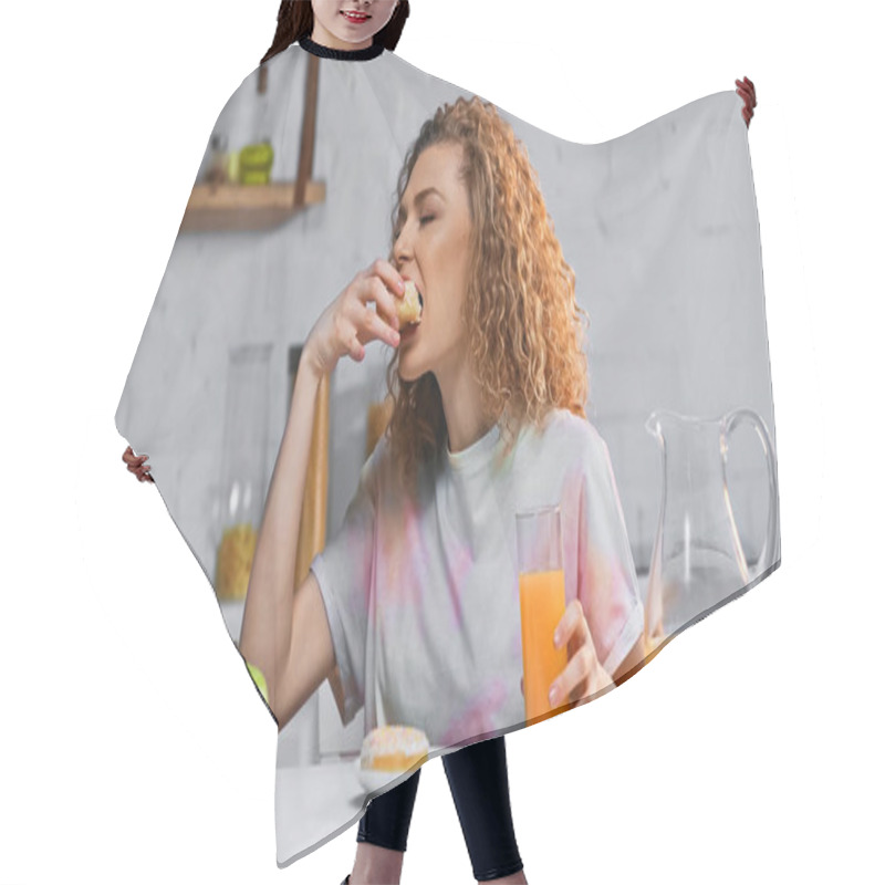 Personality  Curly Woman Eating Sweet Doughnut And Holding Glass Of Orange Juice In Kitchen  Hair Cutting Cape