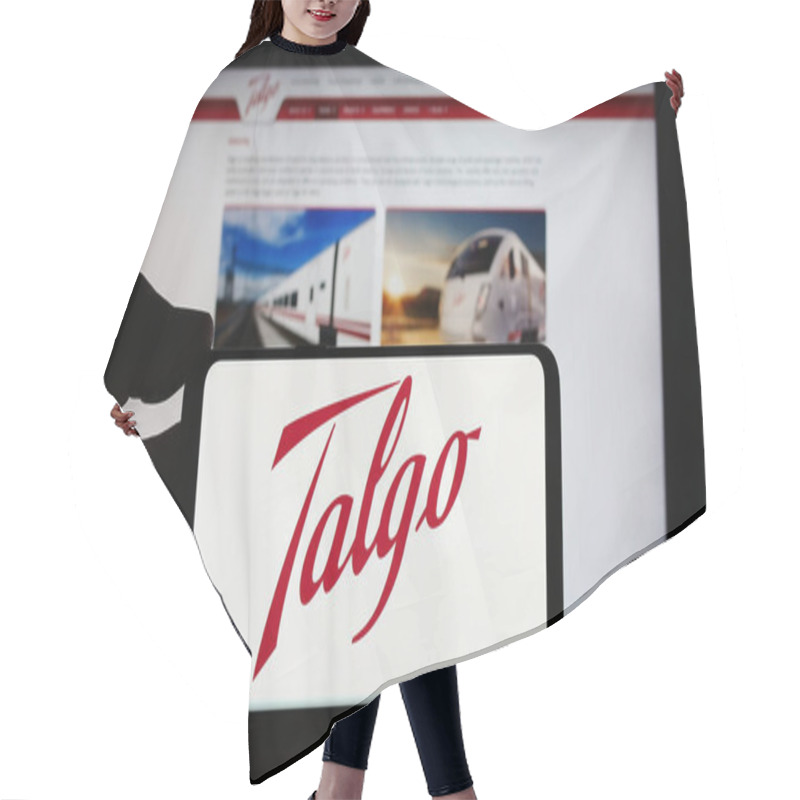 Personality  Stuttgart, Germany - 04-08-2024: Person Holding Cellphone With Logo Of Spanish Train Manufacturing Company Talgo S.A. In Front Of Business Webpage. Focus On Phone Display. Hair Cutting Cape