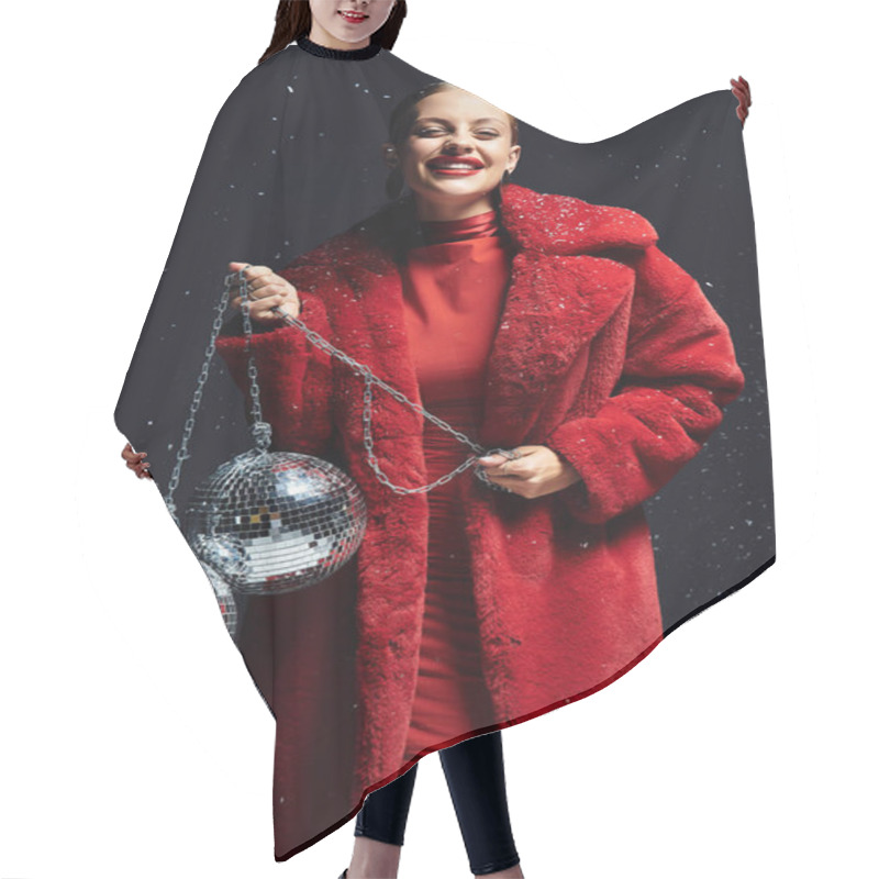 Personality  A Young Woman In A Bright Red Coat Beams Happily While Holding Disco Balls. Hair Cutting Cape