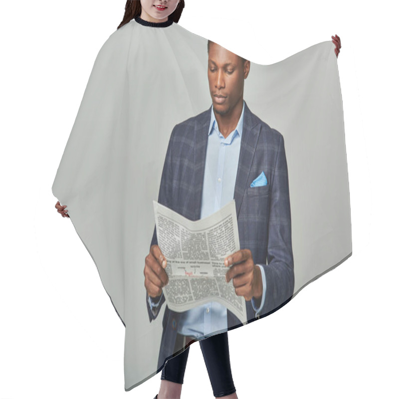 Personality  Handsome African American Businessman In Checkered Blazer Absorbed In Newspaper On Grey Background. Hair Cutting Cape