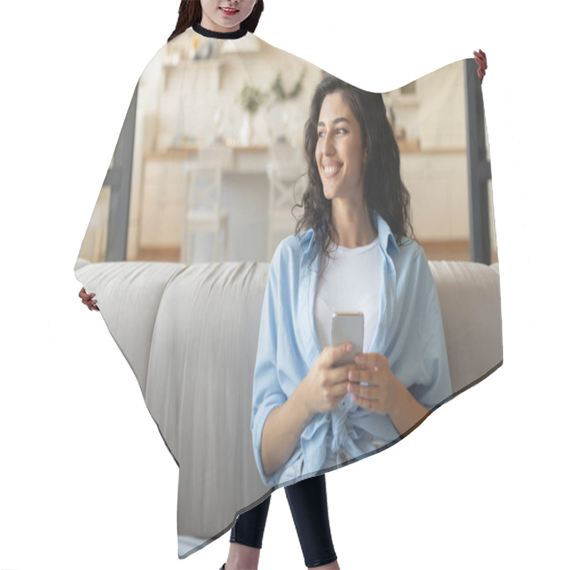 Personality  Portrait Of Smiling Young Woman With Smartphone Sitting On Couch At Home, Using Mobile Device, Copy Space Hair Cutting Cape