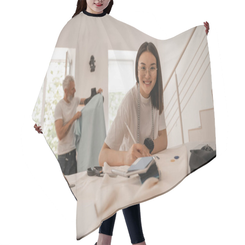 Personality  Smiling Asian Designer Looking At Camera While Working With Cloth  Hair Cutting Cape