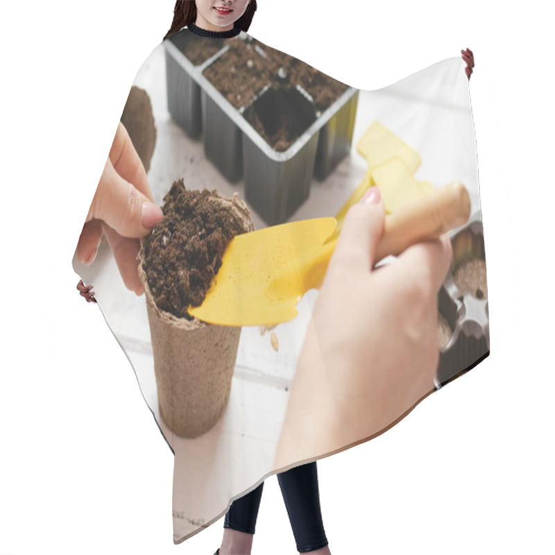 Personality  Woman Sowing Seeds At Home In A Pot For Seedlings, Gardening. Hair Cutting Cape