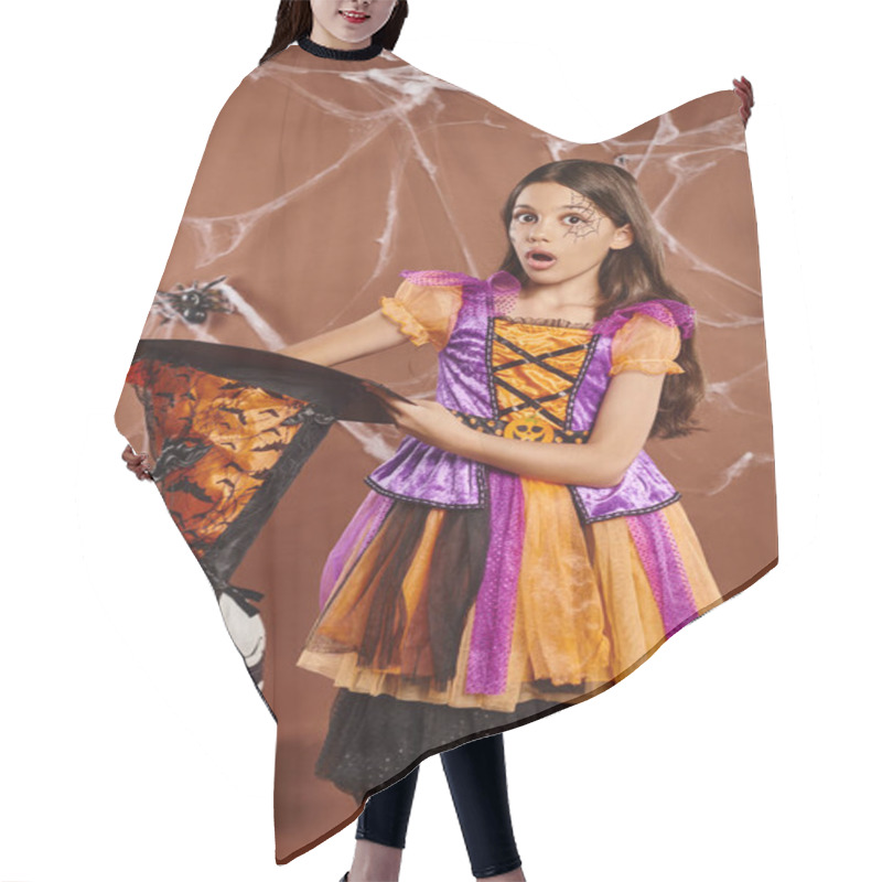 Personality  Shocked Child In Halloween Witch Costume Holding Pointed Hat On Brown Background, Spooky Season Hair Cutting Cape