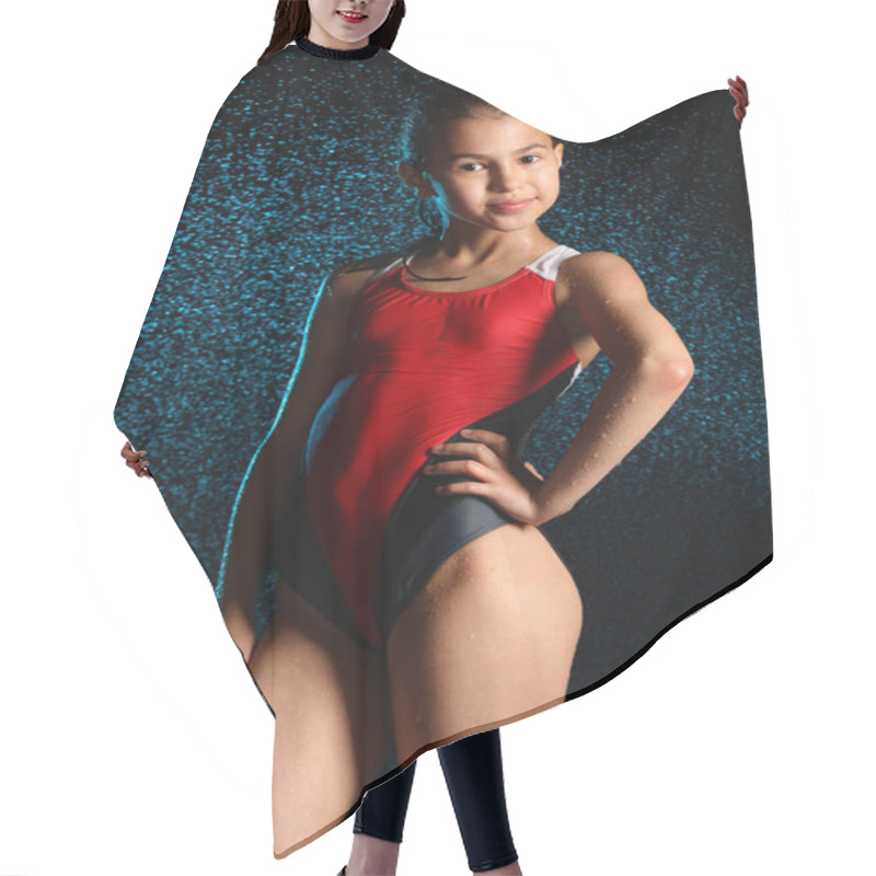 Personality  Knee-length Portrait Of A Slender And Beautiful Swimmer Girl 12 Years Old In A Red One-piece Swimsuit On A Black Background With Splashes Of Water. Hair Cutting Cape