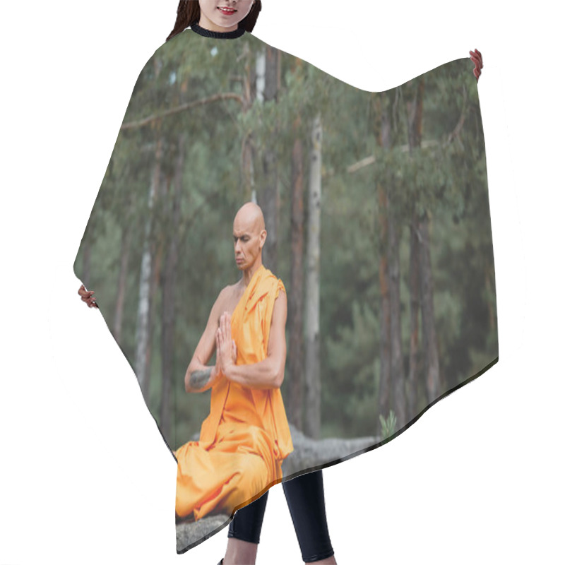 Personality  Buddhist Monk In Orange Kasaya Sitting In Lotus Pose With Praying Hands While Meditating In Forest Hair Cutting Cape