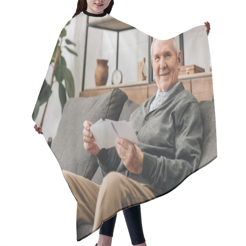 Personality  Cheerful Senior Man With Grey Hair Holding Photos And Sitting On Sofa Hair Cutting Cape