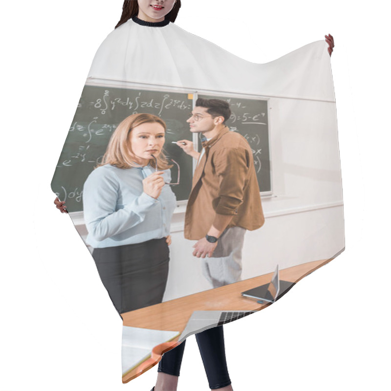 Personality  Teacher Thinking And Holding Glasses In Hand While Student Standing Near Chalkboard  Hair Cutting Cape