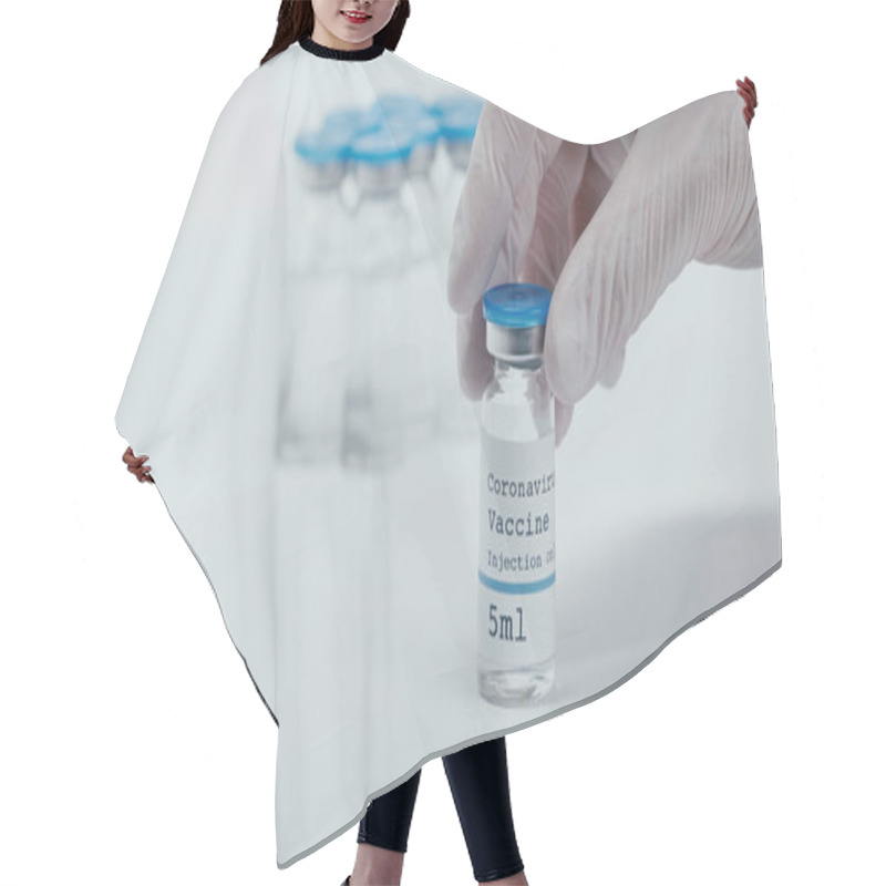 Personality  Cropped View Of Person Holding Bottle With Coronavirus Vaccine Liquid On White  Hair Cutting Cape