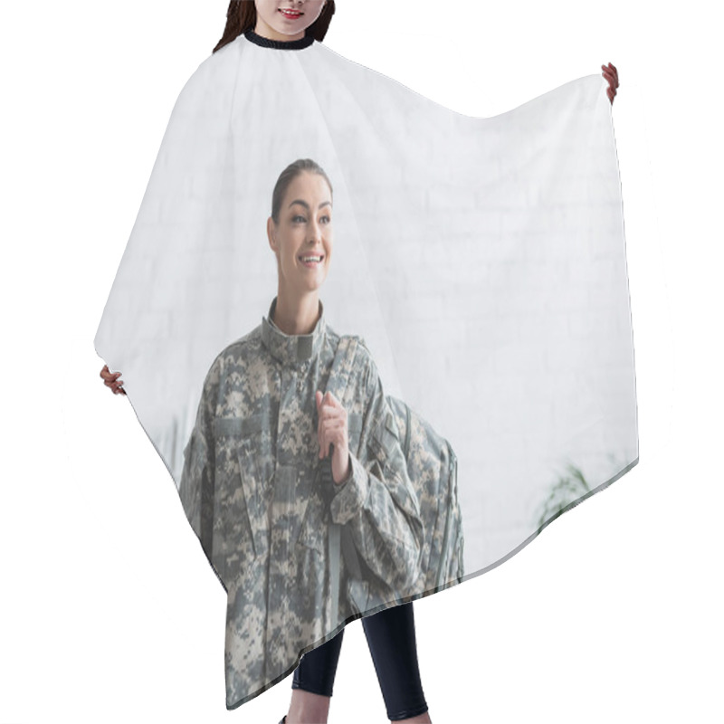 Personality  Cheerful Woman In Military Uniform Holding Backpack At Home  Hair Cutting Cape