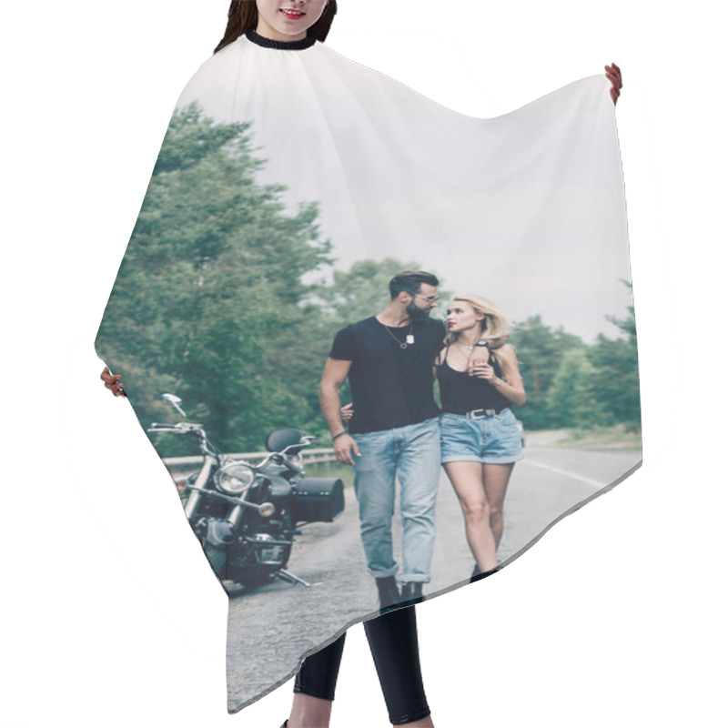 Personality  Young Couple Of Bikers Walking Along Road And Embracing Near Black Motorcycle Hair Cutting Cape