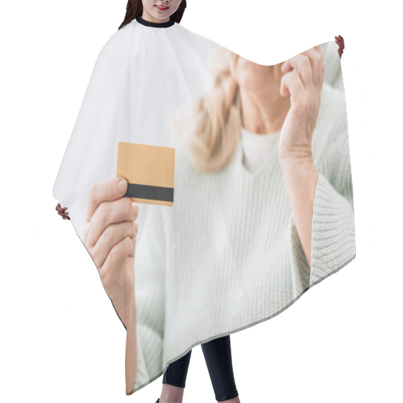 Personality  Selective Focus Of Credit Card In Hand Of Senior Woman Talking At Smartphone  Hair Cutting Cape