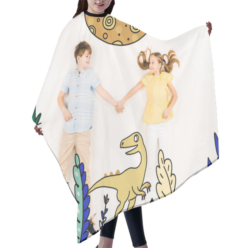 Personality  Top View Of Cheerful Kids Holding Hands Near Dinosaur On White  Hair Cutting Cape