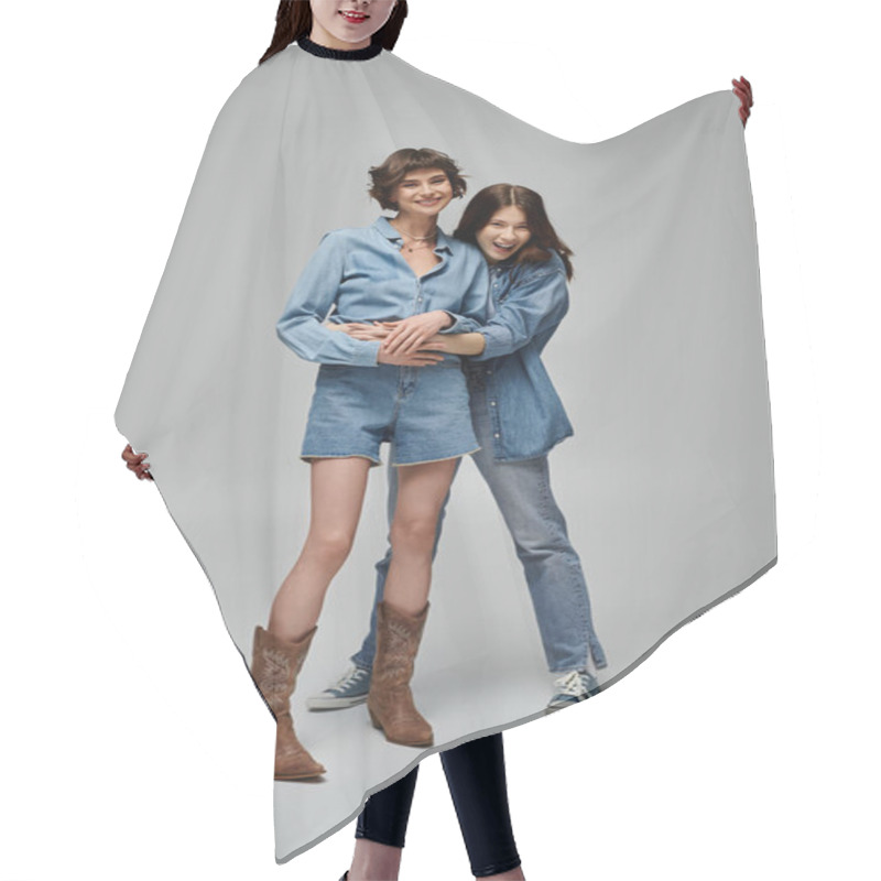 Personality  Two Young Women In Denim Outfits Pose On A Grey Background, Showcasing Their Stylish Fashion Choices. Lgbt Couple Hair Cutting Cape