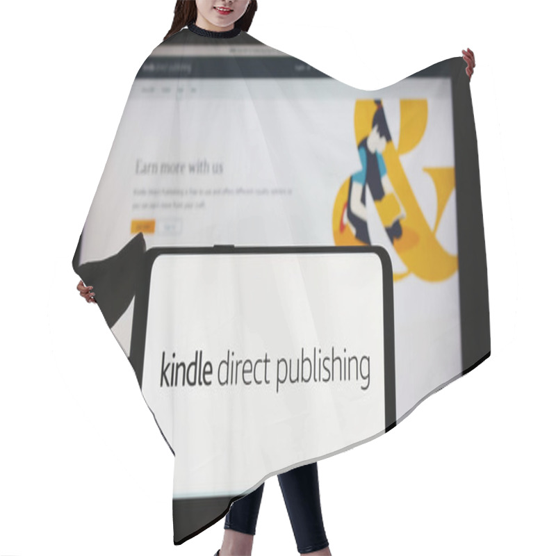 Personality  Stuttgart, Germany - 11-09-2023: Person Holding Smartphone With Logo Of Amazon E-book Platform Kindle Direct Publishing (KDP) In Front Of Website. Focus On Phone Display. Hair Cutting Cape