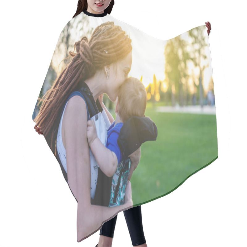 Personality  Young Happy Mom With Baby Son In Ergo Backpack Are Playing In The Park. Sunny Summer Day. The Concept Of Modern Parents Hair Cutting Cape